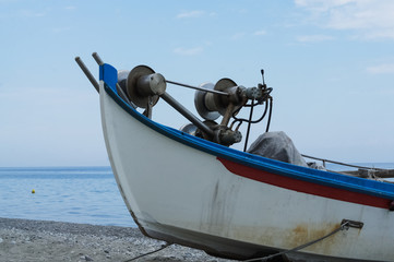 Abandoned fishing boat on beach near sea.