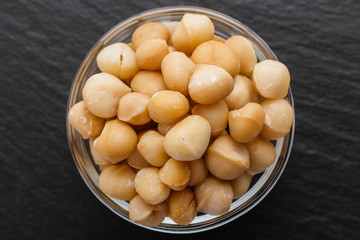 delicious macadamia nuts on a dark stone background
