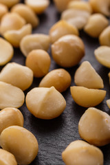 delicious macadamia nuts on a dark stone background