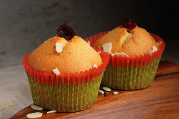 Two cupcakes in New Year's paper on a wooden plate