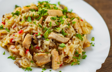 Chicken Breast with Rice, mushroom  and vegetables in white plate on wooden table background