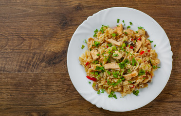 Chicken Breast with Rice, mushroom  and vegetables in white plate on wooden table background