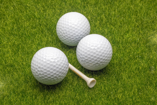 Close up view golf balls and tee on grass background.