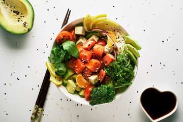 poke bowl with salmon, avocado, cucumbers, arugula, broccoli, rice, carrots, cheese and chukha with...