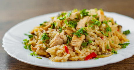 Chicken Breast with Rice, mushroom  and vegetables in white plate on wooden table background