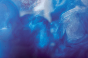 abstract background with purple and blue mixing swirls of paint