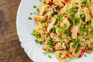 Chicken Breast with Rice, mushroom  and vegetables in white plate on wooden table background