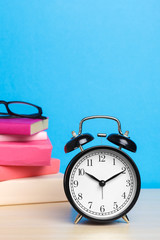Back to school background with books and alarm clock