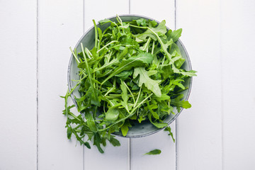 Bowl with fresh green salad arugula rucola on a wooden Black or White background - 237734157