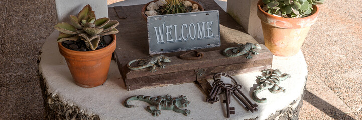 Metal Sign Welcome on the old well with wooden lid