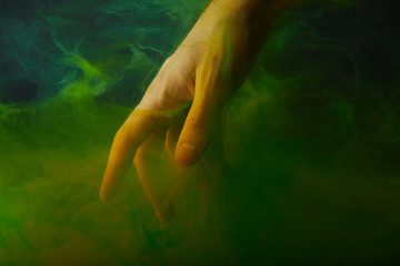 Obraz na płótnie Canvas male hand in water with green paint