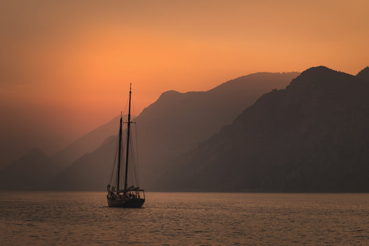 Sailboat sailing at sunset on the background of a mountain range. Traveling  inspiration concept