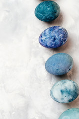 Easter eggs with marble stone effect on grey concrete background with blank space