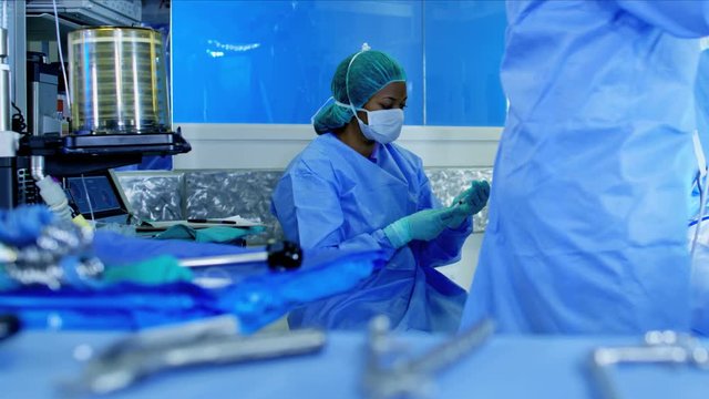 Surgical hospital Laparoscopic Operation carried out by Caucasian male and female specialist team in scrubs and African American Anesthesiologist 