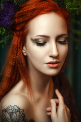 Fototapeta premium Young red head model is posing with a creative makeup 