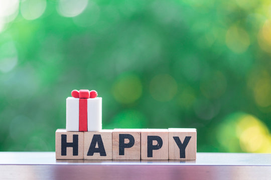 Wooden block with "HAPPY" text with gift box on top