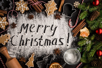 Inscription MERRY CHRISTMAS on powdered sugar  background.  