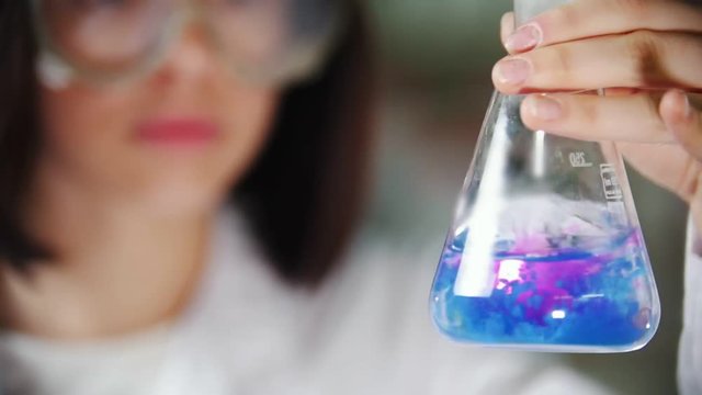 A woman mixing a flask with a chemical substance