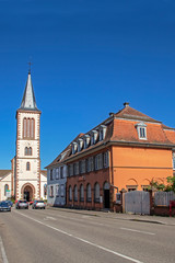 Fototapeta na wymiar Titre : Munster. Rue principale et église catholique Saint Léger . Alsace. Haut-Rhin. Grand Est 