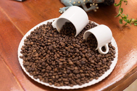 Coffee beans and two white cups as a decoration on the table