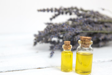 lavender oil in a glass bottle on a background of fresh flowers. Horizontal close-up