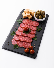 delicious sliced salami on a stone plate white background