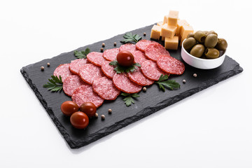delicious sliced salami on a stone plate white background