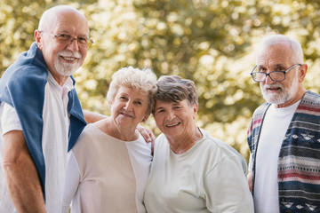Group of senior friends smiling and having fun together at park