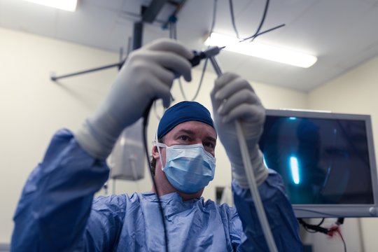 Female surgeon holding medical instrument in operation theatre