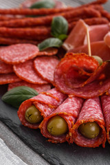 Cold smoked meat plate on a rustic wooden background