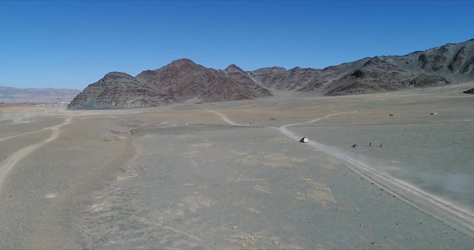 4k 60 fps Mongolia Aerial view of Altai desrt track with 4x4 driving - large view with dust cloud