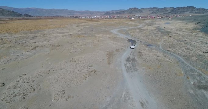 4k 60 fps Mongolia Aerial view of Altai desrt track with 4x4 driving - catching up to get closer