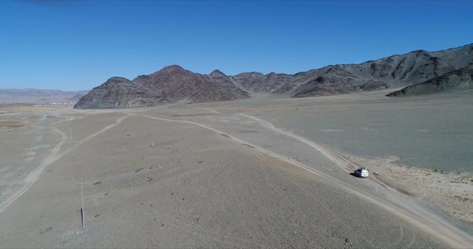 4k 60 fps Mongolia Aerial view of Altai desrt track with 4x4 driving - driving fast toward mountain