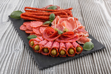 Cold smoked meat plate on a rustic wooden background