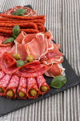 Cold smoked meat plate on a rustic wooden background