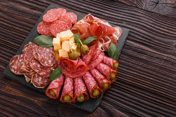 Cold smoked meat plate on a rustic wooden background