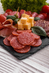 Cold smoked meat plate on a rustic wooden background