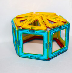 children's magnetic designer for the development of motor skills, thinking and imagination. construction assembled from multi-colored parts of a children's magnetic designer.