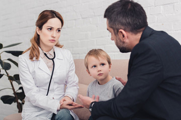 pediatrist and man talking about sick boy in living room