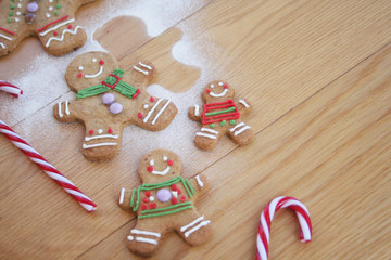Christmas background with gingerbread men cookies on wooden table with selective focus
