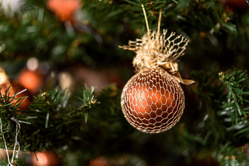Christmas brown ball hanging on pine branches with festive background