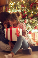 Obraz na płótnie Canvas Young couple opening a present on a Christmas.