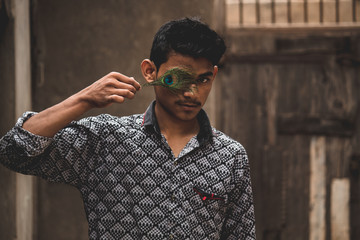 Man having peacock feather in his hand