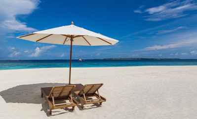 Sonnenschirm und Liegen am Strand Atoll Insel Malediven