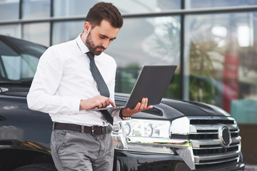 Man is a man working on a laptop and testing on mobile devices.