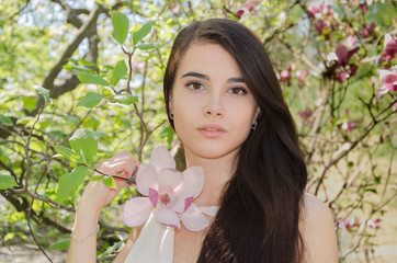 Naklejka premium beautiful girl in the flowered garden