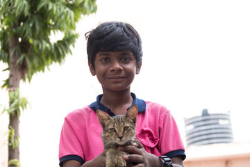 Young boy holding kitten in his hand