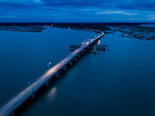 Fototapeta na wymiar Aerial view of traffic moving across bridge at night with light trails.