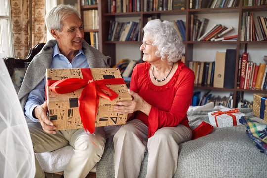 senior man with presents spending Christmas together with woman.