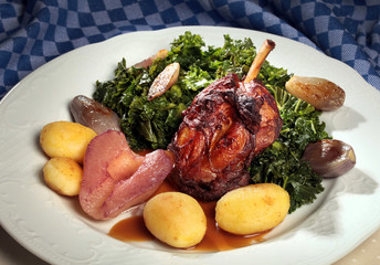 Knusprige Schweinshaxe mit Grünkohl und leicht angebratenen Salzkartoffeln und eingelegten Zwiebeln